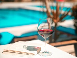 a glass of red wine sitting on a table at Kraal Hotel Vlore in Vlorë