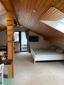 Un dormitorio con una cama y un techo de madera. en Roof Heaven Ferienwohnung, en Blaichach