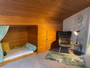 Habitación con 1 cama y 1 silla en una habitación en Roof Heaven Ferienwohnung, en Blaichach