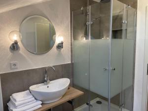 Un baño con lavabo y ducha de cristal. en Roof Heaven Ferienwohnung, en Blaichach
