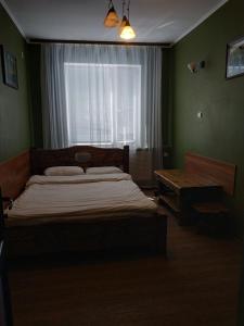 a bedroom with a large bed and a window at mini-hotel Neptun in Rivne