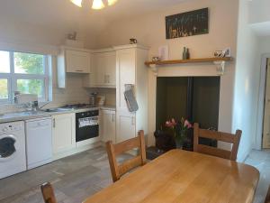 a kitchen with a wooden table and a dining room at Hillview Cottage in Bantry