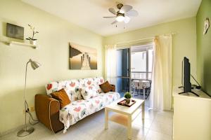 a living room with a couch and a tv at Alquilaencanarias- Medano Apartment Bogavante in El Médano