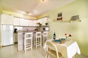 cocina con mesa, sillas y barra en Alquilaencanarias- Medano Apartment Bogavante, en El Médano 10 fotos más