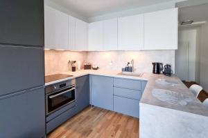 una cocina con armarios azules y blancos y fregadero en Relax Suite, en Mörbisch am See