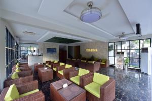 a restaurant with brown and green chairs and windows at Hotel La Orilla Muzaffarabad in Muzaffarabad