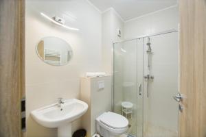a bathroom with a toilet and a sink and a shower at Elegant & Spacious – Central Apartment in Oradea