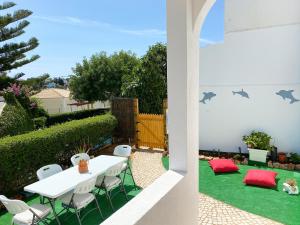 een tuin met een tafel en stoelen op het gras bij CASA AQUA - Carvoeiro - WiFi, Terrace & BBQ in Carvoeiro