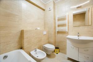 a bathroom with a white toilet and a sink at Elegant & Spacious – Central Apartment in Oradea