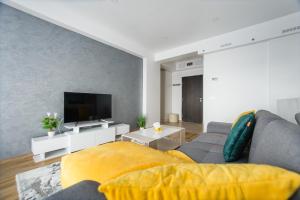 a living room with a couch and a tv at Elegant & Spacious – Central Apartment in Oradea +28 photos