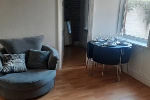 a living room with a blue chair and a table at Sunderland short stay 2-bed retreat apartment in Fulwell in Monkwearmouth