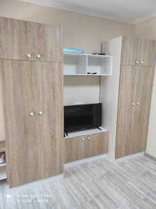 a living room with wooden cabinets and a tv at Коттедж Науки 65 in Kharkiv