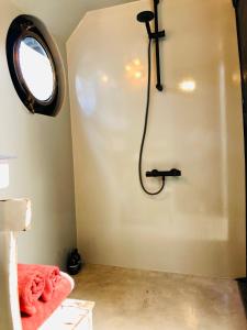 La salle de bains est pourvue d'une douche avec un tuyau noir. dans l'établissement Houseboat Tante Piet, à Amsterdam
