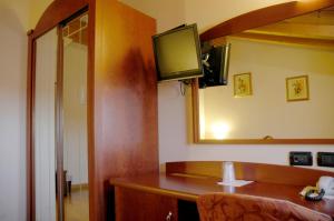 Habitación con mesa, TV y espejo. en Hotel San Paolo, en Camposampiero