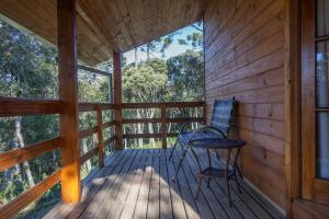 a porch of a cabin with two chairs on it at Pousada Recanto do Lobo Chalés em Urubici in Urubici