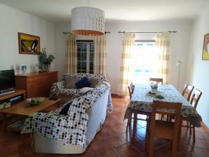 - un salon avec un canapé et une table dans l'établissement SW Beach House Zambujeira do Mar, à Zambujeira do Mar