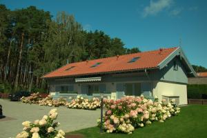 a building with a lot of flowers in front of it at Preilos Perliukas in Preila