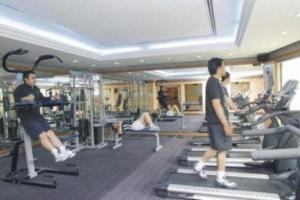 Grand Palace Hotel في ميري: رجلان يمارسان الآلات في صالة رياضية