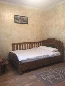 ein Schlafzimmer mit einem Bett mit einem Kopfteil aus Holz in der Unterkunft mini-hotel Neptun in Riwne