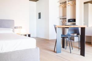 a bedroom with a bed and a desk with a bed and chairs at Encanto Agriturismo & Private SPA in Visogliano