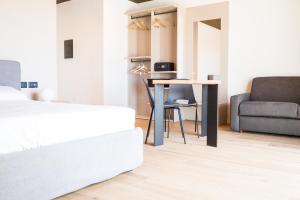 a bedroom with a bed and a table and a couch at Encanto Agriturismo & Private SPA in Visogliano