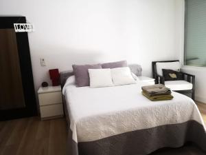 ein Schlafzimmer mit einem großen Bett mit weißer Bettwäsche in der Unterkunft Home & garden suites center Granada in Granada