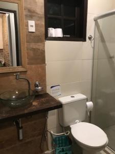 a bathroom with a toilet and a sink at Praia Comprida Flats in Abraão