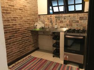 a kitchen with a counter and a brick wall at Praia Comprida Flats in Abraão
