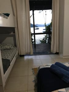 Schlafzimmer mit Etagenbetten und Meerblick in der Unterkunft Praia Comprida Flats in Abraão