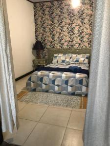 um quarto com uma cama com uma parede estampada em Praia Comprida Flats em Abraão