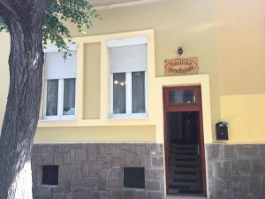 a building with two windows and a door at Bazilika Vendégház in Eger