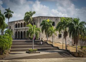 a building with palm trees in front of it at Malecon Premium Rooms & Hotel in Santo Domingo