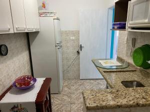 una piccola cucina con frigorifero e lavandino di Apartamento na Praia Grande - Aviação a Praia Grande