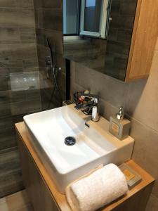 bagno con lavandino bianco e specchio di Fontana Leone a Spílion