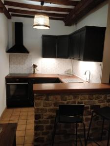 a kitchen with black cabinets and a counter top at Le Portail Du Mont in Montpinchon