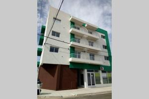 wysoki biały budynek z zielonym przycinaniem na ulicy w obiekcie Alojamientos Litoral - 3A w mieście Gualeguaychú
