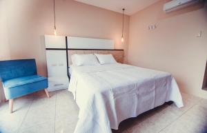 a bedroom with a bed and a blue chair at Golden Hotel in Quevedo