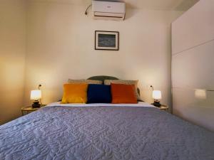 1 dormitorio con 1 cama grande y almohadas coloridas en Celtis Shade House en Virpazar