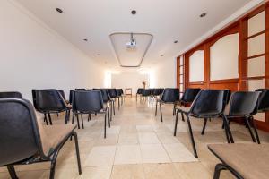 a conference room with black chairs and a white wall at Hotel Lukas in Medellín