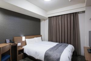 Dormy Inn EXPRESS Sendai Seaside في سيندايْ: غرفه فندقيه بسرير ونافذه