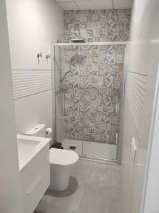 uma casa de banho branca com um WC e um chuveiro em APARTAMENTO TURISTICO LYRA BAENA em Baena