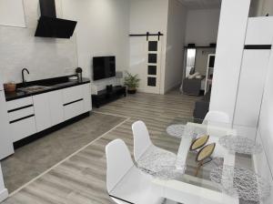 uma sala de estar com uma mesa de vidro e uma cozinha em APARTAMENTO TURISTICO LYRA BAENA em Baena