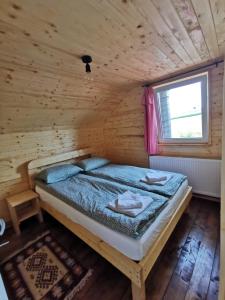 a bedroom with a bed in a wooden cabin at Cabana Orizont Marisel in Mărişel