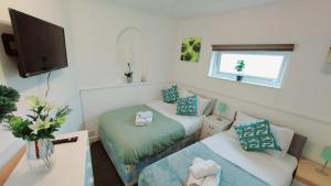 a small room with two beds and a tv at Gillings Villa -Perfect For Long & Short Stays in Gillingham