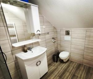 a bathroom with a white sink and a toilet at Apartmani "Marina" in Otočac