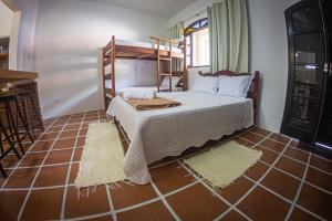 1 dormitorio con litera y suelo de baldosa en Aldeia Ubatuba, en Ubatuba