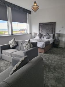 a living room with a bed and a couch at Royal Seabank Hotel in Blackpool
