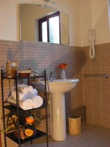 a bathroom with a sink and a mirror and towels at Pietra Preziosa Bed & Breakfast in Pietra Ligure
