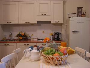 ピエトラ・リーグレにあるPietra Preziosa Bed & Breakfastのキッチン(テーブル、フルーツバスケット付)