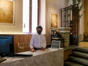 a man wearing a mask sitting at a desk with a computer at Casona Alonso 10- Hotelito Mexicano in Guanajuato